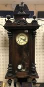 A circa 1900 walnut cased Vienna regulator wall clock with spreadeagle and ball surmount, the