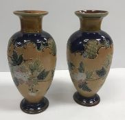 A pair of Doulton Lambeth relief work floral decorated vases with flared rims, 29.6 cm highCondition