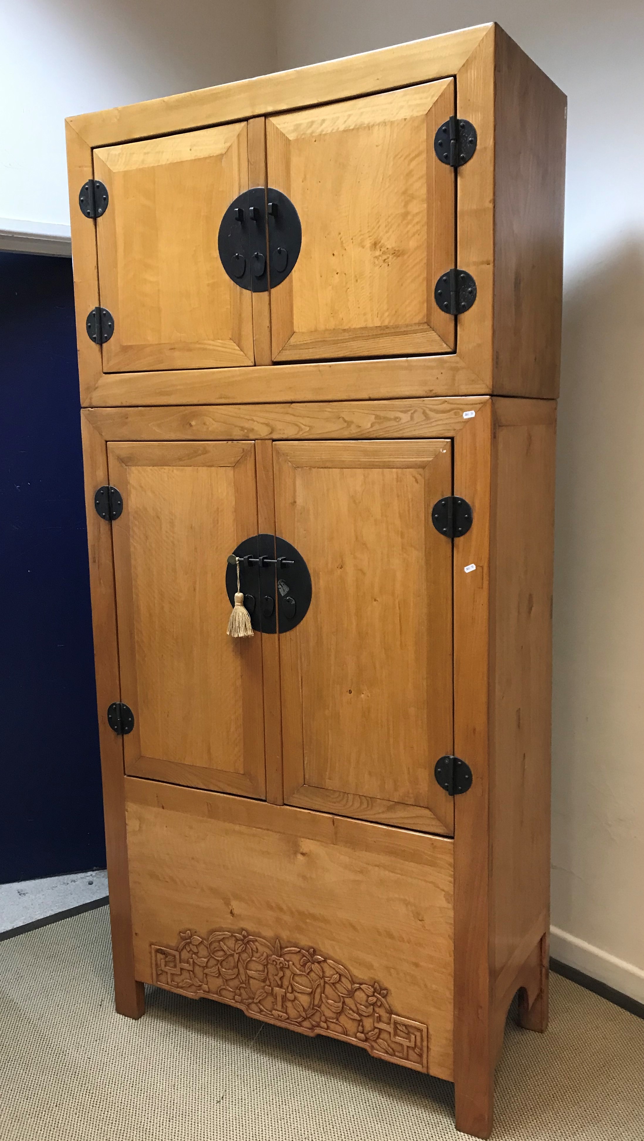 An Eastern blond elm cupboard with two small cupboard doors over two larger cupboard doors and