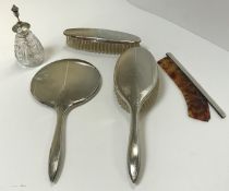 A silver four piece dressing table brush and mirror set with comb, a sterling silver mounted cut