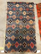 A Caucasian carpet, the central panel set with three repeating medallions on an orange ground,