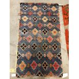 A Caucasian carpet, the central panel set with three repeating medallions on an orange ground,