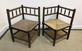 A pair of 19th Century stained beech framed bobbin turned corner chairs with rush seats, 43 cm x
