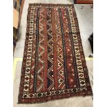 A Kasak carpet, the central panel set with striped design on a red and blue and cream background,
