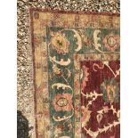 A Ziegler design carpet, the central panel set with all-over scrolling foliate decoration on a red