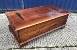 A modern teak living room chest with rising lid over a bank of twelve small drawers raised on