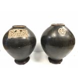 A pair of Oriental treacle glazed ovoid vases with panel / medallion decoration or simulated text,