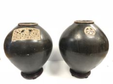 A pair of Oriental treacle glazed ovoid vases with panel / medallion decoration or simulated text,
