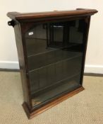 A late Victorian mahogany framed hanging wall cabinet with single glazed door enclosing adjustable