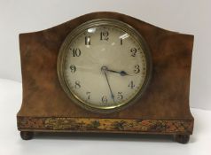 An early 20th Century French walnut cased mantel clock with chinoiserie banded decoration, raised on