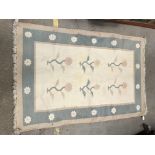 A modern rug, the central panel set with floral sprays on a cream ground, within a flower head