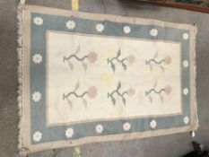 A modern rug, the central panel set with floral sprays on a cream ground, within a flower head