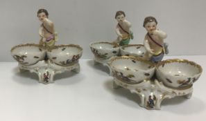 A set of three 19th Century Berlin porcelain twin bowl salts with putti decoration, bearing blue