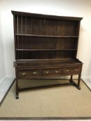 A late 18th Century oak dresser, the boarded two tier plate rack with moulded cornice above two