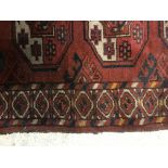 A Bokhara rug, the central panel set with repeatin