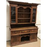 A late Victorian pine dresser with two glazed doors and three shelves over three drawers, a