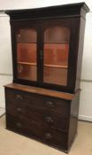 A Victorian oak bookcase cabinet, the two glazed doors enclosing two shelves over three long