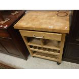 A modern butchers block type kitchen table with single drawer over a shelf, wine rack and further