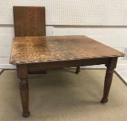 A Victorian oak rectangular extending dining table with single extra leaf on turned and ringed