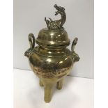 A Chinese brass lidded censer, the lid with dragon finial, the base set with twin handles and lion