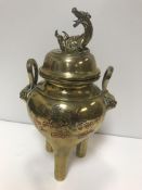 A Chinese brass lidded censer, the lid with dragon finial, the base set with twin handles and lion