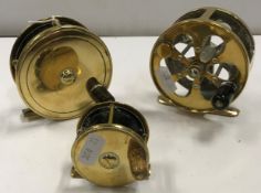 A collection of three brass fly fishing reels to include an Army & Navy 31/4" plate wind reel, an