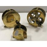 A collection of three brass fly fishing reels to include an Army & Navy 31/4" plate wind reel, an