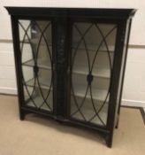An Edwardian mahogany and carved display cabinet with scrolling foliate decoration, the two glazed