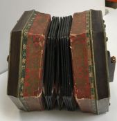 A twenty-one button unnamed rosewood concertina with decorated paper bellows together with a further