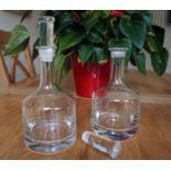 Pair of circular, clear glass decanters,