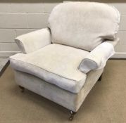 A modern upholstered scroll arm chair on