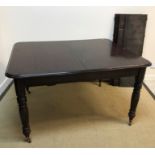 A mahogany extending dining table in the