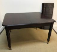 A mahogany extending dining table in the