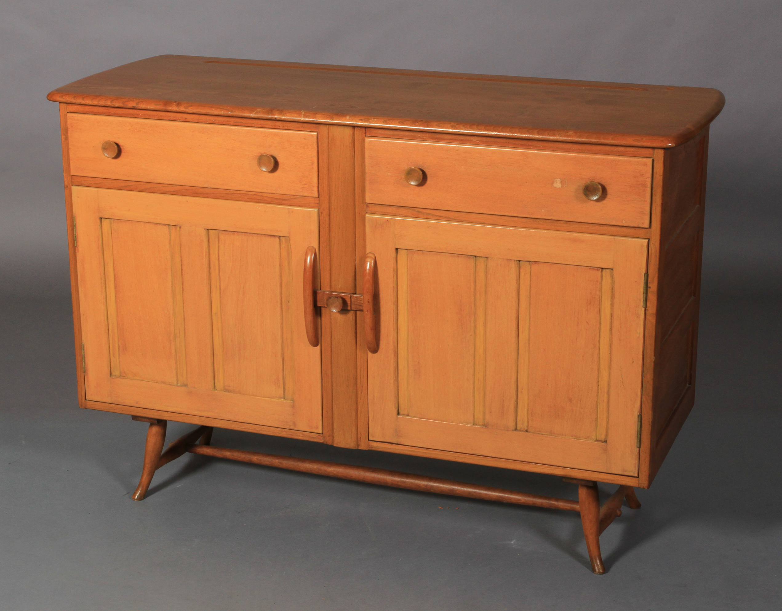 Ercol, a pale elm sideboard, c.1955/60 two frieze drawers above two twin indented panel cupboard