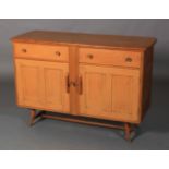 Ercol, a pale elm sideboard, c.1955/60 two frieze drawers above two twin indented panel cupboard