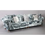 A four seater sofa upholstered in pale blue crushed velvet, on turned legs with chrome castors,