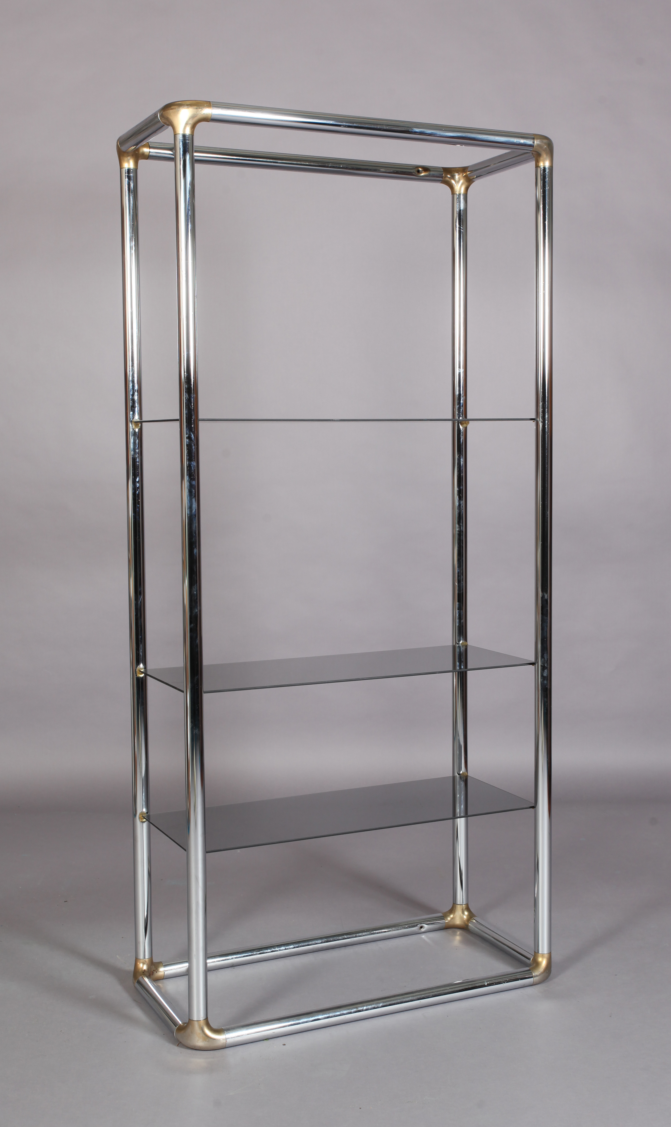 A chrome and gilt metal display stand with three smoked glass shelves, 84cm wide x 41cm deep x 183cm