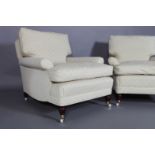 A pair of Howard style armchairs on turned legs with ceramic castors