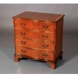 A George III style mahogany crossbanded serpentine chest of four long graduated drawers with brass