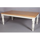 An oak rectangular dining table by Clarity Arts, cream painted apron and turned legs, with extra