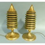 A pair of copper heaters of stacked conical form on a circular spreading base, fitted with a large