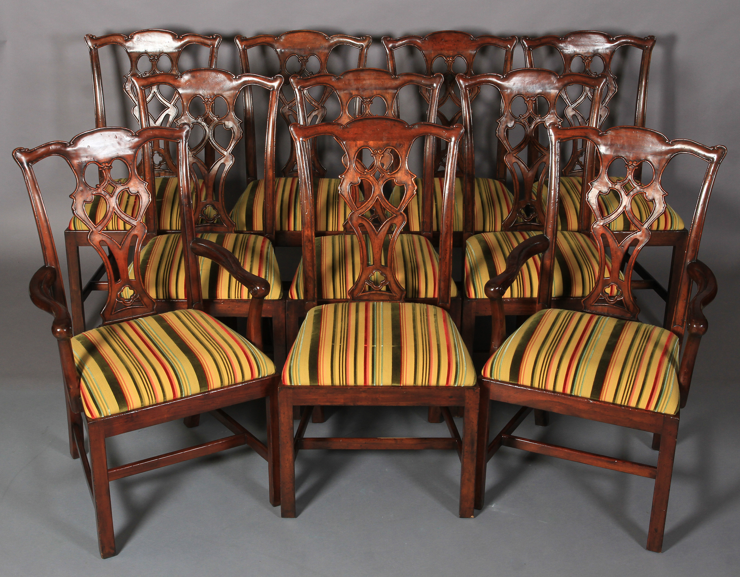 A set of ten hardwood dining chairs of mid 18th century design, having a striped velvet and flat