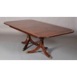 A Jonathan Charles figured mahogany crossbanded and boxwood banded dining table of Regency design,