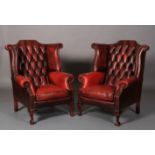 A pair of ox-blood button back winged leather armchairs, close-nailed, on cabriole legs