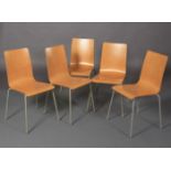 A set of five beech laminate stacking chairs on pale grey tubular legs