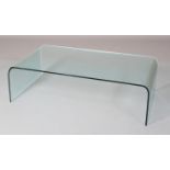 A curved glass coffee table 130cm long x 69cm wide x 38cm high