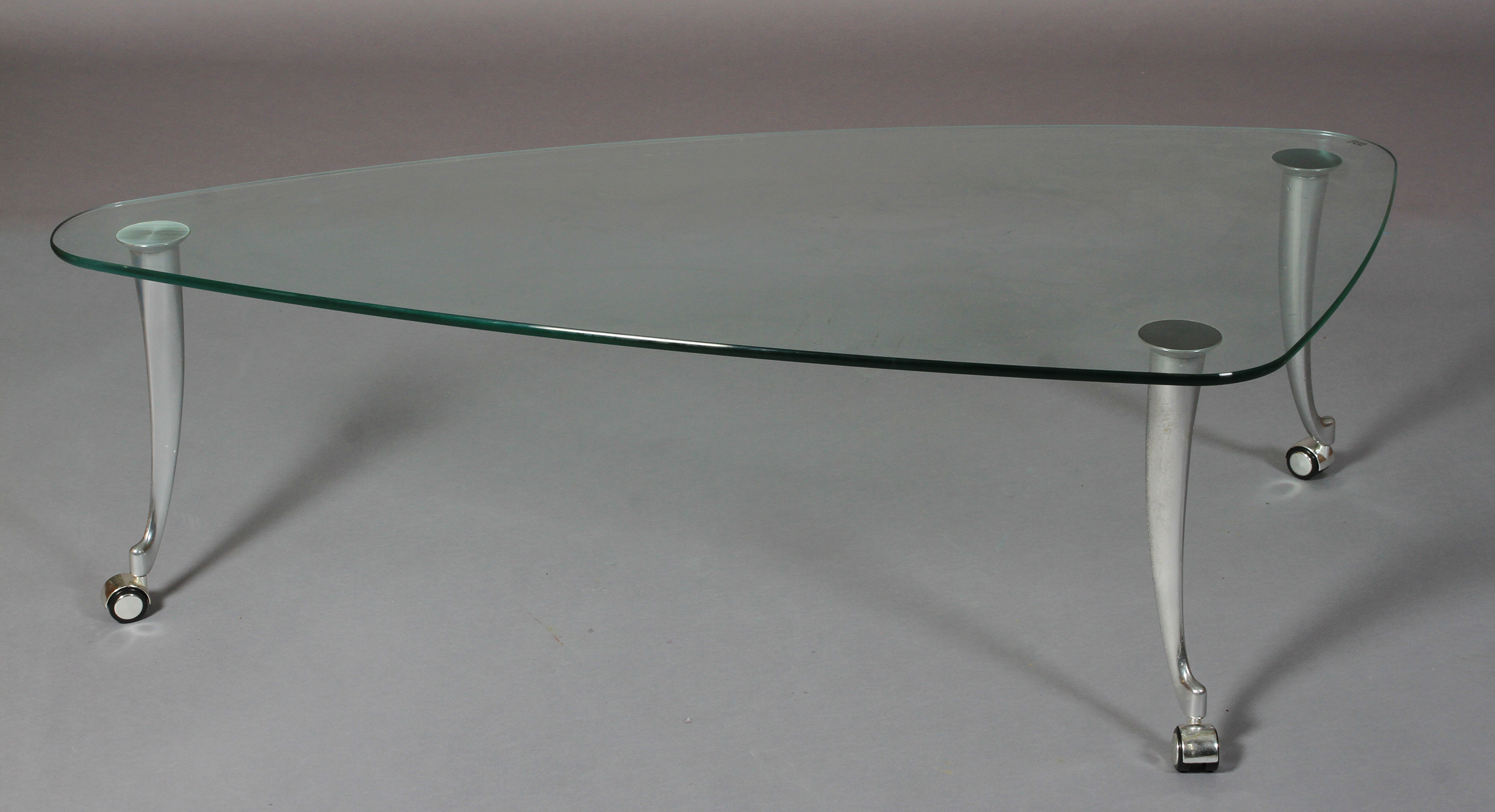 Rolf Benz - a glass and brushed aluminium coffee table, rounded triangular form on swept legs and