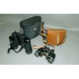 Two pairs of field binoculars, one by Pentax, the other by Broadhurst, Clarkson & Son and in a