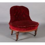 A Victorian nursing chair with low button back and bowed stuffed over seat upholstered in claret