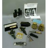 A pair of binoculars and a smaller pair, various penknives, a pair of brass paw furniture feet, a